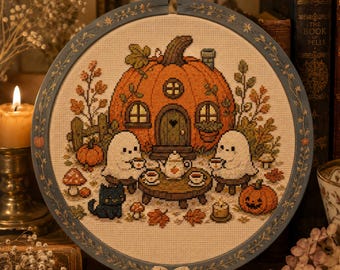 May include: A circular cross-stitch embroidery in a wooden hoop featuring a pumpkin-shaped house, two white ghost figures sitting at a small table with a teapot and cups, a black cat, autumn leaves, mushrooms, and a jack-o'-lantern.
