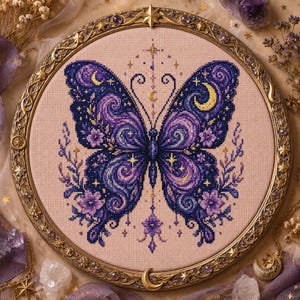 Peut inclure: Un tambour à broder circulaire contenant un motif au point de croix représentant un papillon aux ailes violettes et bleu foncé avec des motifs tourbillonnants, des croissants de lune jaunes et de petites étoiles sur un tissu rose clair.