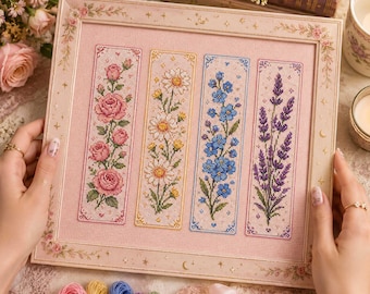 Può includere: Un ricamo a punto croce rettangolare incorniciato con quattro pannelli verticali su tessuto a griglia rosa chiaro. I pannelli mostrano motivi floreali: rose, margherite, nontiscordardime e lavanda, racchiusi in una cornice decorativa.