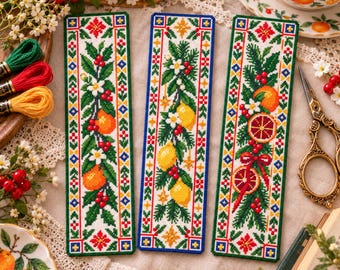May include: Three rectangular cross-stitch bookmarks featuring embroidered citrus fruit, green leaves, white blossoms, and red berries. Each bookmark is bordered by a geometric pattern in red, blue, and green thread on white fabric.
