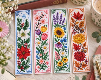 May include: Four rectangular bookmarks featuring cross-stitch embroidery designs. Each bookmark displays a different seasonal theme: a winter poinsettia, spring tulips and daisies, summer sunflowers and wildflowers, and autumn maple leaves with chrysanthemums.