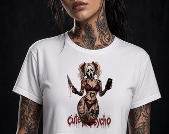 May include: A white short-sleeved crop top featuring a graphic print of a character wearing a ghost mask, red lingerie, and pigtails, holding a bloody knife and a smartphone. The text "Cute but psycho" is printed in red below the character.