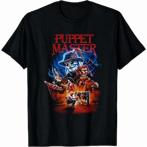May include: A black short-sleeve t-shirt featuring a graphic print with the text PUPPET MASTER in red. The design displays a central figure in a hat with a hook hand, surrounded by various puppet characters, a person sitting in a chair, and a glowing trunk.