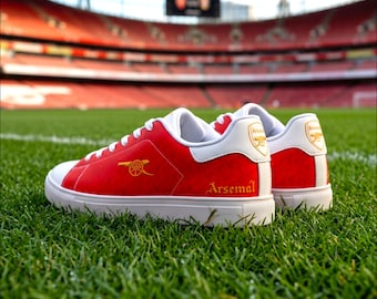 Tênis de couro do Arsenal Gunners, inspirado na temporada de campeões de 2026, modelo personalizado de cano baixo, vermelho e branco, para torcedores do norte de Londres.