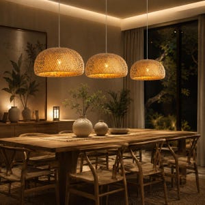 May include: Three dome-shaped pendant lights made of woven light brown bamboo material hang from the ceiling. Each fixture features a fine lattice pattern that emits a warm, soft glow, illuminating the dining area below with a gentle light.