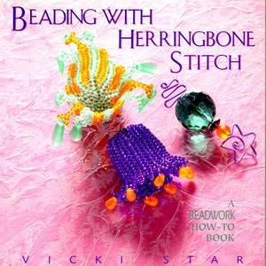 May include: A book titled "Beading with Herringbone Stitch" by Vicki Star. The book cover features a pink background with colorful beaded jewelry, including a purple flower, a green and orange flower, and a green bead.
