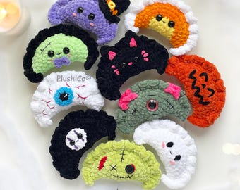 Può includere: Una collezione di dieci peluche a forma di mezzaluna con vari design a tema Halloween, tra cui una strega, una zucca, un mostro, un bulbo oculare e un fantasma. Ogni articolo lavorato all'uncinetto mostra il testo PlushiCo.