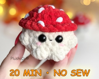 Può includere: Un piccolo peluche a forma di fungo all'uncinetto con un cappello rosso brillante a pois bianchi e un gambo bianco testurizzato. La figura ha grandi occhi di sicurezza neri e piccole guance ricamate in rosa. Il testo riporta PlushiCo, 20 MIN, NO SEW.