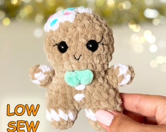 Può includere: Un pupazzo all'uncinetto a forma di omino di pan di zenzero beige con una decorazione di glassa bianca sulla testa con zuccherini colorati, occhi neri, un papillon verde menta e dettagli bianchi su braccia e gambe. Testo LOW SEW visibile.