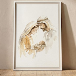 May include: A framed watercolour print depicting a nativity scene with a figure in a head covering holding a swaddled infant, while another figure with a beard and head covering stands beside them, all rendered in soft shades of brown and beige.