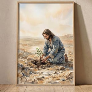 Könnte beinhalten: Ein gerahmter Aquarelldruck, der eine Person mit langem braunem Haar und Bart in einem blauen Gewand zeigt, die in einer trockenen, felsigen Landschaft kniet und einen kleinen grünen Setzling unter einem hellgelben Himmel in die Erde pflanzt.