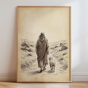 Könnte beinhalten: Ein gerahmter Kunstdruck mit einer sepiafarbenen Strichzeichnung einer Figur in einem langen Gewand, die auf einem Feldweg durch eine hügelige Landschaft geht, begleitet von einem kleinen Lamm, das neben ihr läuft, in einem hellen Holzrahmen.