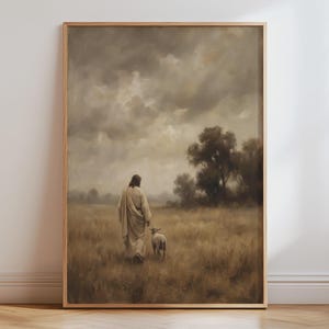 Könnte beinhalten: Ein gerahmter Kunstdruck, der eine Figur in einem langen, hellen Gewand zeigt, die durch ein goldbraunes Feld neben einem kleinen Schaf geht. Die Szene spielt unter einem bewölkten, trüben Himmel mit dunklen Bäumen im Hintergrund.