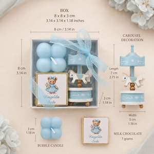 May include: A gift set containing a light blue bubble candle, a square chocolate bar with a teddy bear illustration and the text Hoşgeldin Seda, and a carousel decoration. The box measures 8 x 8 x 3 cm. The carousel is 7 cm in length.