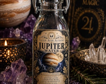 May include: A clear glass swing-top bottle labeled Alien Aloe Alchemy Jupiter Water. The label features an illustration of the planet Jupiter, text detailing ritual preparation, and a volume of 2 fl oz. The bottle has a white stopper with a red seal.