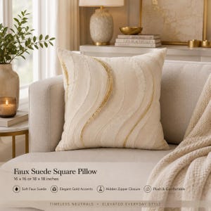 May include: A square faux suede pillow in cream featuring textured, wavy lines with gold accents. The pillow measures 16 by 16 by 18 inches and includes a hidden zipper closure. The surface has a plush texture with decorative gold detailing.