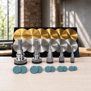 May include: A set of five metal mandrels with knurled bases, arranged in descending order of size. Behind them are six gold and six silver circular metal discs. Ten small, round, teal-colored abrasive pads are placed in front of the mandrels.