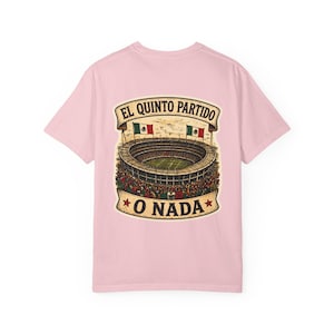 May include: A light pink t-shirt featuring a graphic of a stadium with the text "EL QUINTO PARTIDO O NADA". The graphic includes the Mexican flag and the stadium is filled with people.