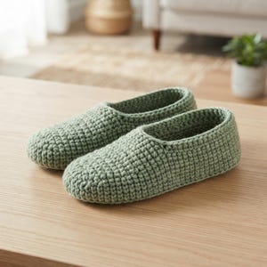 Puede incluir: Un par de zapatillas de color verde salvia confeccionadas con un punto de ganchillo denso y texturizado. Las zapatillas presentan un diseño de punta redondeada, una abertura baja y una construcción de hilo uniforme con un patrón de bucles.