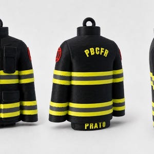 Peut inclure: Un ornement en forme de veste de pompier noire avec des bandes réfléchissantes jaunes et grises, un emblème rouge sur la manche et le texte PBCFR et PRATO en lettres jaunes au dos. La veste comporte une petite boucle sur le dessus.