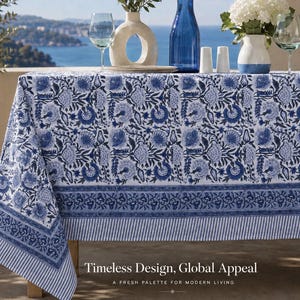 May include: A rectangular tablecloth featuring a white base with a repeating blue floral block print pattern, a wide decorative border, and a striped edge. The text "Timeless Design, Global Appeal" and "A FRESH PALETTE FOR MODERN LIVING" is visible.