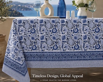 May include: A rectangular tablecloth featuring a white base with a repeating blue floral block print pattern, a wide decorative border, and a striped edge. The text "Timeless Design, Global Appeal" and "A FRESH PALETTE FOR MODERN LIVING" is visible.