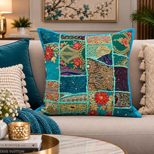 Handgemaakte turquoise patchwork kussenhoes met veelkleurig borduurwerk.