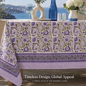 Könnte beinhalten: Eine rechteckige Tischdecke mit einem sich wiederholenden Blumenmuster in Violett- und Olivgrüntönen auf weißem Grund, abgeschlossen mit einer dekorativen Bordüre aus violetten Blumenmotiven und feinen vertikalen Streifen am unteren Rand.