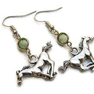 May include: Silver horse earrings with green gemstone accents. The horse charms are in a running pose.
