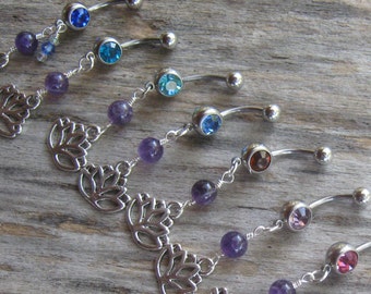 May include: A set of nine belly button rings with amethyst beads and a lotus flower charm. Each ring features a different colored gem stone: blue, turquoise, light blue, dark blue, brown, pink, and purple.