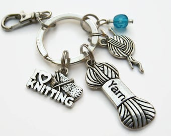 May include: Silver keychain with a charm that says "I Love Knitting" and a yarn ball charm that says "Yarn".