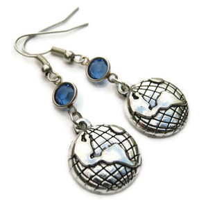 May include: Silver earrings with a globe design and blue crystal accents.