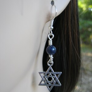 Pu&ograve; includere: Orecchini pendenti in argento con un ciondolo a forma di stella di David in argento e una perla di lapislazuli blu.