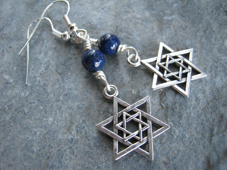 Pu&ograve; includere: Orecchini d'argento con un ciondolo a forma di stella di David in argento e una perla di lapislazuli blu.