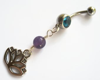 May include: A silver belly button ring with a blue gem, a purple amethyst bead, and a silver lotus flower charm.