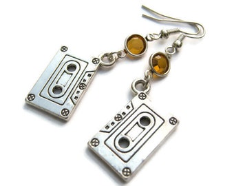 May include: Silver cassette tape earrings with amber colored crystal accents.