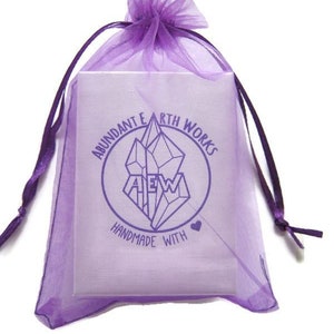 May include: Purple organza gift bag with a white label that says "Abundant Earth Works" and "Handmade with Love" in a circle around a crystal graphic.