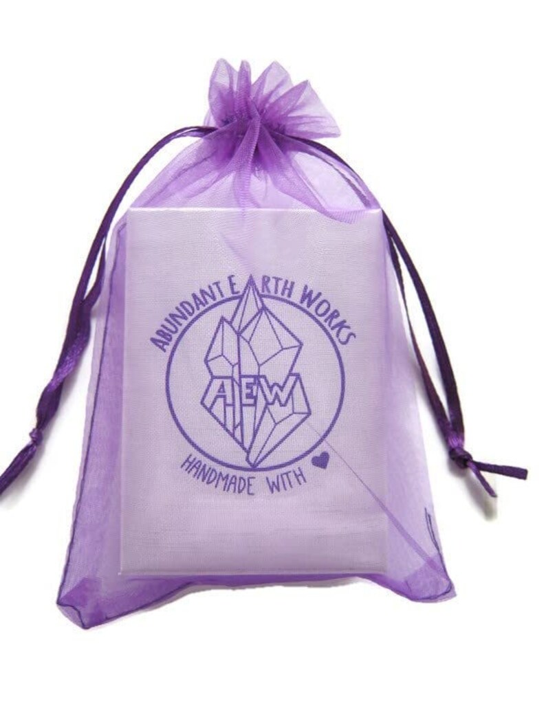 May include: Purple organza gift bag with a white label that says "Abundant Earth Works" and "Handmade with Love" in a circle around a crystal graphic.