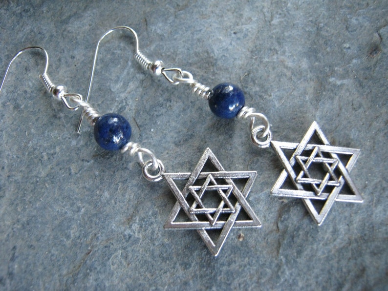 Pu&ograve; includere: Orecchini d'argento con una pietra preziosa blu e un ciondolo a forma di stella di David in argento.