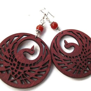 May include: A pair of red wood earrings with a carved phoenix design and red carnelian beads.