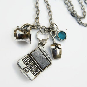 May include: A silver chain necklace with multiple charms, including a coffee pot, a laptop, a computer mouse, and a blue gemstone.