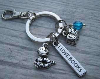 May include: Silver keychain with a book charm, a blue bead, a snake charm, and a tag that says "I Love Books".