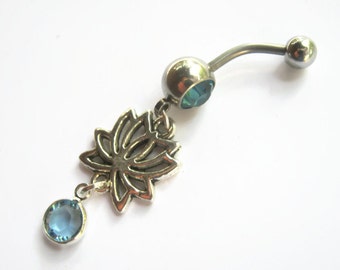 May include: A silver belly button ring with a dangling lotus flower charm and two blue crystal accents.