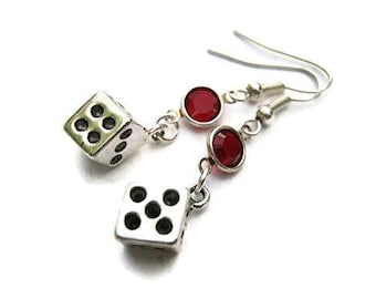 Puede incluir: Pendientes de plata con un strass rojo y un dije de dado de plata.