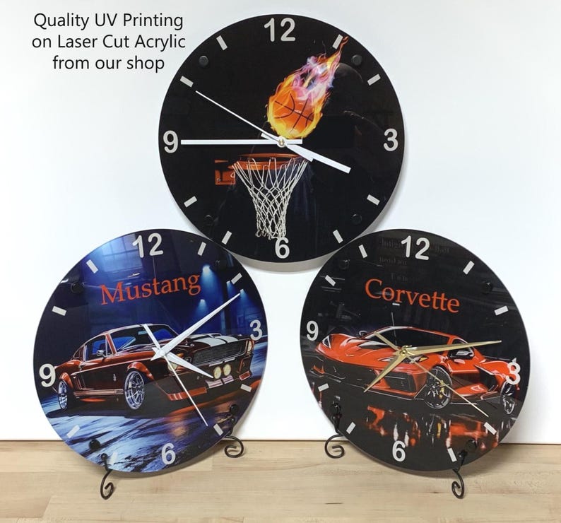 May include: Three circular wall clocks made of laser-cut acrylic with UV printing. The top clock features a flaming basketball and hoop. The bottom left clock displays a classic Mustang car, and the bottom right clock shows a Corvette sports car.
