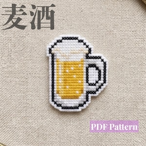 Puede incluir: Un diseño de punto de cruz de una jarra de cerveza llena de líquido dorado y espuma blanca, delineado con hilo negro. Los caracteres chinos 麦酒 están situados en la esquina superior izquierda y el texto PDF Pattern en la inferior derecha.