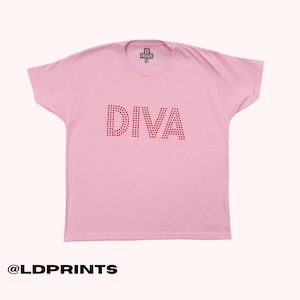 May include: A light pink short-sleeved t-shirt featuring the word DIVA printed in a red dotted pattern across the chest. The interior neck label displays the text LD PRINTS and the size S. The bottom left corner includes the text @LDPRINTS.