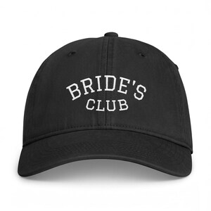 Peut inclure: Une casquette de baseball noire avec le texte brodé en blanc BRIDE'S CLUB arqué sur le panneau avant. La casquette présente une calotte structurée, une visière incurvée et un bouton sur le dessus, fabriquée dans un tissu noir uni.