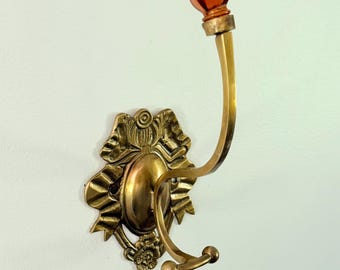 Perchero de pared de latón vintage estilo victoriano con lazos y remate de cristal ámbar con forma de flor.