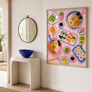 Peut inclure: Une impression d'art encadrée représentant une illustration colorée d'un repas japonais sur un fond à grille rose. L'œuvre montre des bols de ramen avec des œufs et des nouilles, divers sushis, de l'edamame, des agrumes et des sauces.
